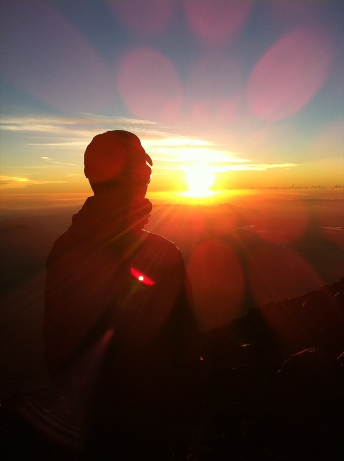 朝日に照らされた山頂でのプロフィール写真